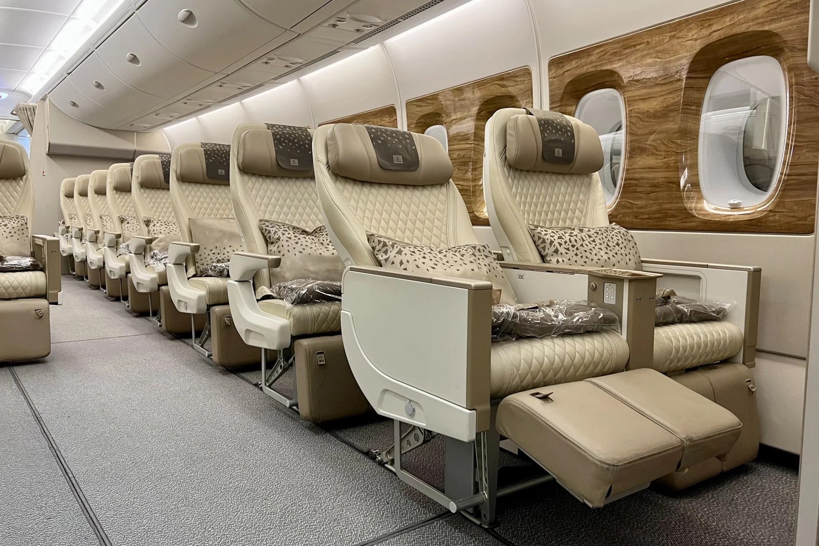 Premium economy cabin with wider seats, extra legroom, and a calm lighting mood on an international flight